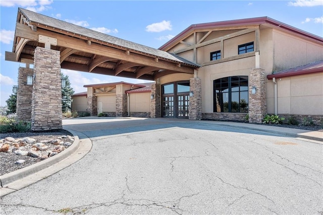 view of parking / parking lot featuring driveway and french doors