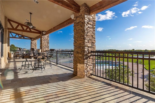 view of patio featuring a balcony, outdoor dining area, and ceiling fan