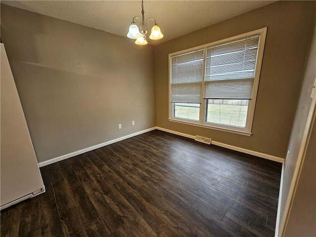 4307 211th St, Belton, MO 64012 - unfurnished room with a chandelier, dark wood-type flooring, baseboards, and a textured ceiling