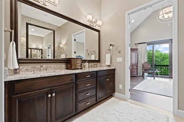 17005 Bradshaw St, Overland Park, KS 66221 - full bathroom with double vanity, vaulted ceiling, baseboards, and tile patterned floors