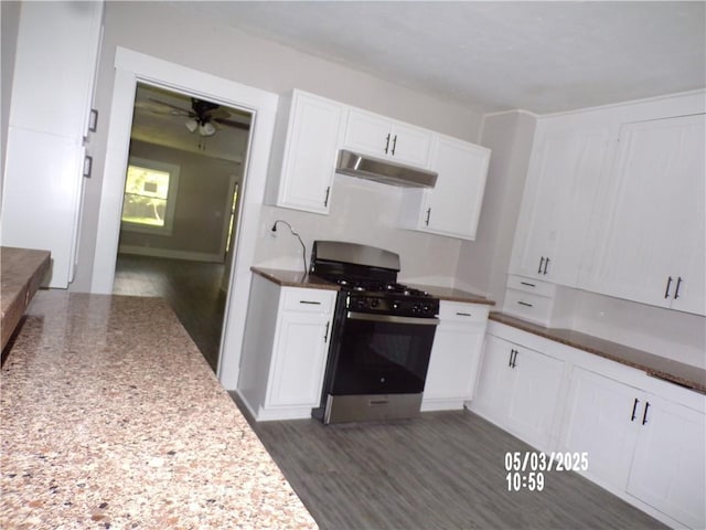 kitchen with stainless steel gas range, a ceiling fan, white cabinetry, dark wood finished floors, and under cabinet range hood