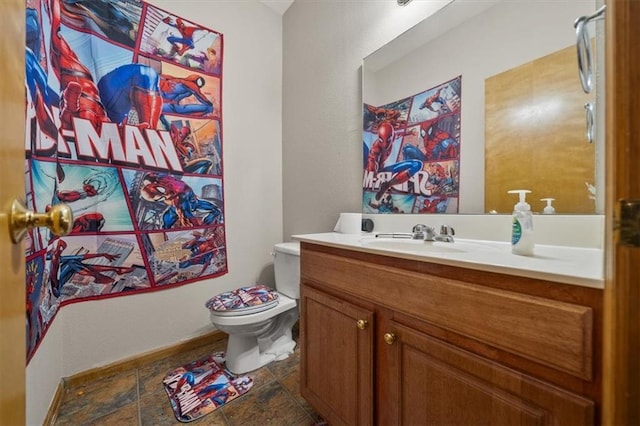 425 Thornton St, Leavenworth, KS 66048 - bathroom with toilet, vanity, baseboards, and stone finish flooring