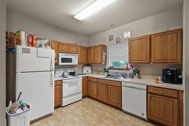 425 Thornton St, Leavenworth, KS 66048 - kitchen with white appliances, a sink, brown cabinetry, and light countertops