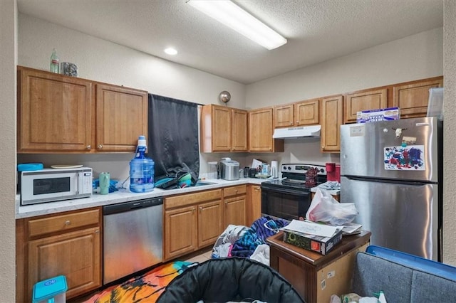 425 Thornton St, Leavenworth, KS 66048 - kitchen featuring stainless steel appliances, under cabinet range hood, a sink, light countertops, and a textured ceiling
