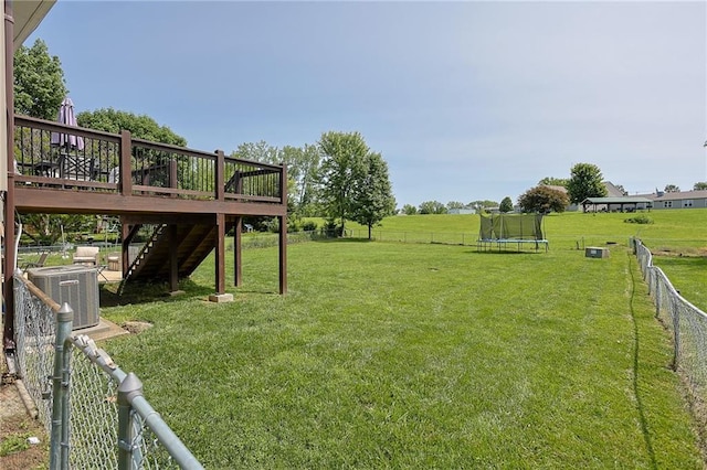 211 Carla St, Excelsior Springs, MO 64024 - view of yard with a trampoline, stairs, a wooden deck, and central AC