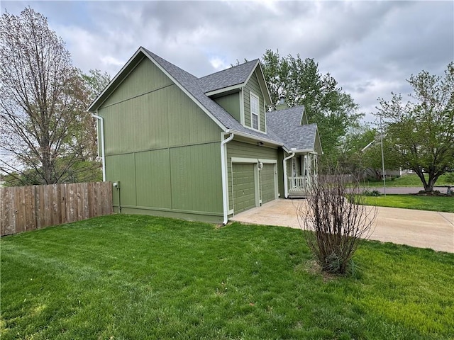 view of side of property featuring a lawn, driveway, a shingled roof, and fence