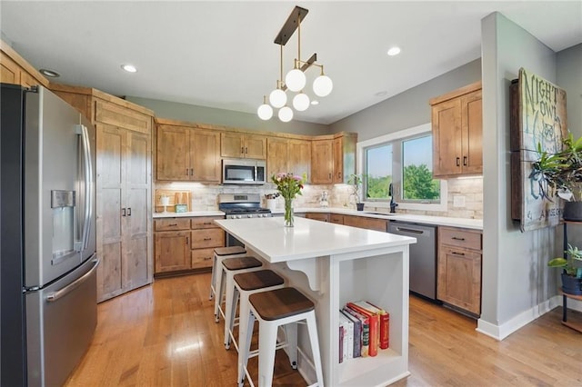 3716 NW 76th St, Kansas City, MO 64151 - kitchen featuring stainless steel appliances, light wood-style flooring, light countertops, a kitchen breakfast bar, and tasteful backsplash