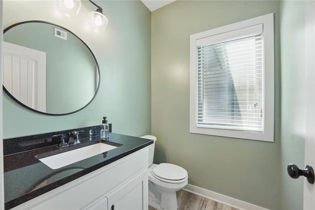 3716 NW 76th St, Kansas City, MO 64151 - bathroom featuring wood finished floors, toilet, baseboards, and vanity