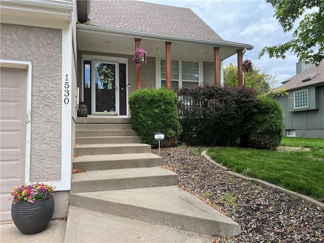 1530 Horseshoe Dr, Raymore, MO 64083 - property entrance featuring stucco siding, covered porch, and a garage