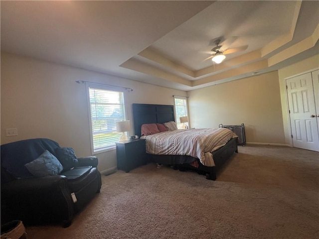 1530 Horseshoe Dr, Raymore, MO 64083 - carpeted bedroom featuring a tray ceiling, baseboards, and a ceiling fan