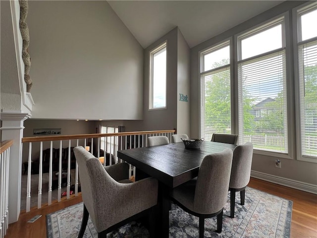 1530 Horseshoe Dr, Raymore, MO 64083 - dining room featuring plenty of natural light, lofted ceiling, wood finished floors, and baseboards