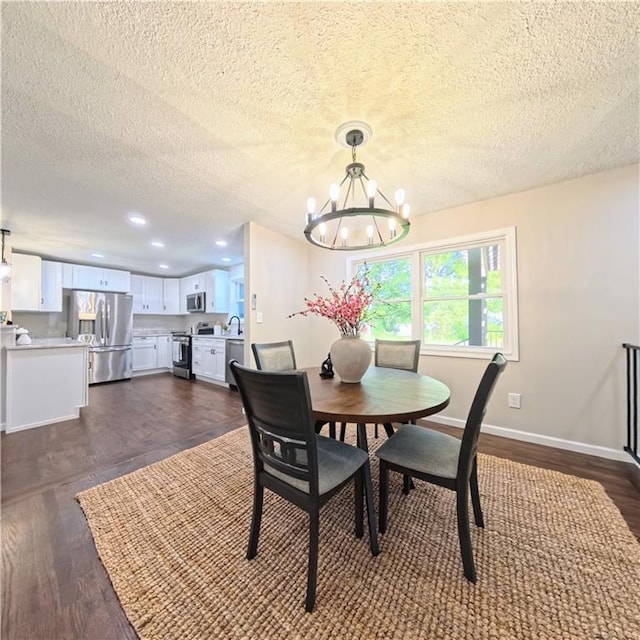 dining space with a chandelier, a textured ceiling, baseboards, dark wood finished floors, and recessed lighting