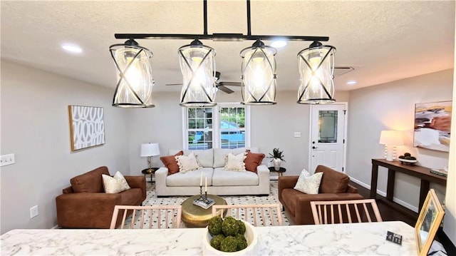 living room featuring a textured ceiling, recessed lighting, baseboards, and wood finished floors