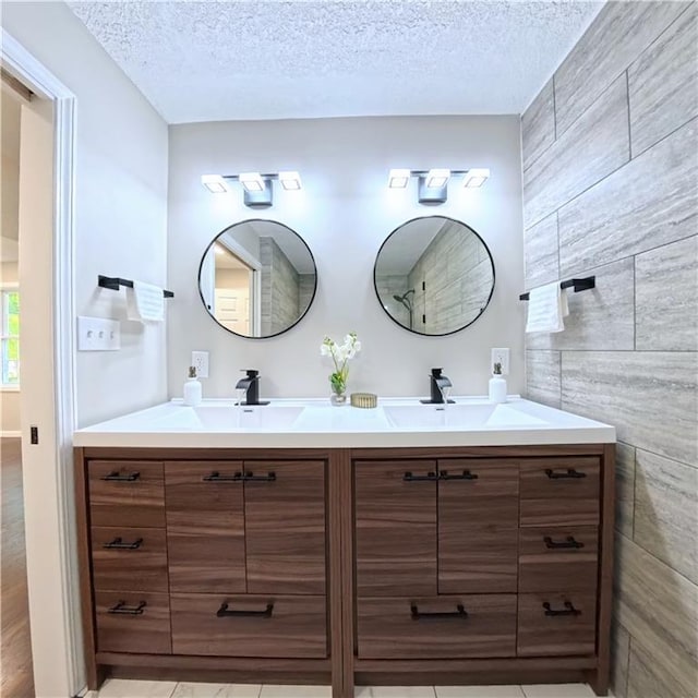 bathroom featuring a textured ceiling and double vanity