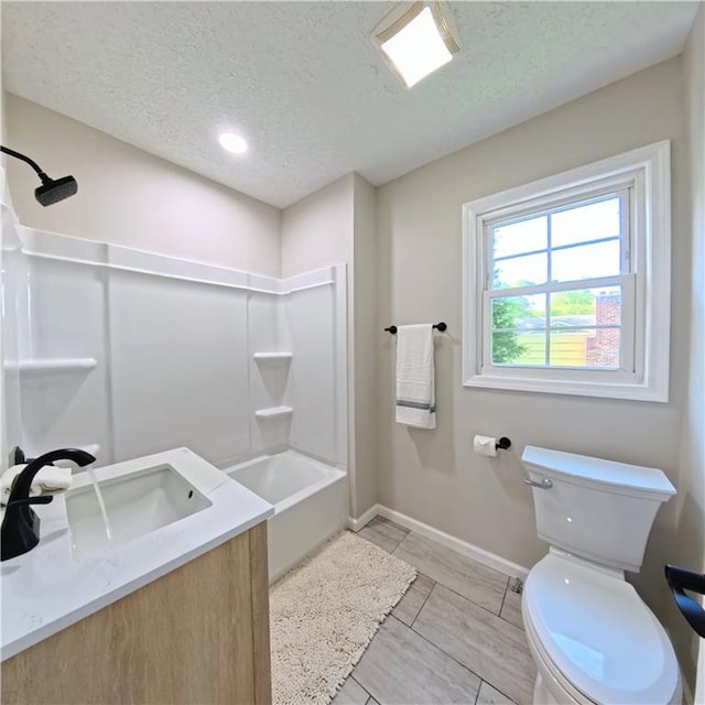 full bath featuring a textured ceiling, toilet, a sink, washtub / shower combination, and baseboards