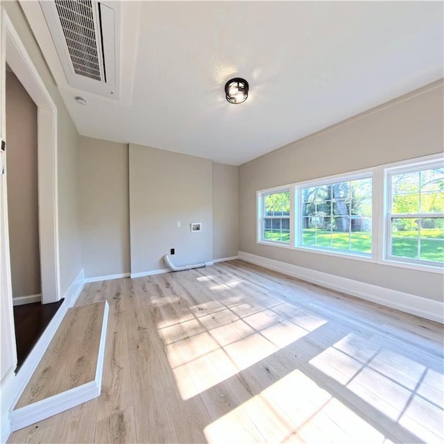 empty room featuring baseboards and light wood-style flooring