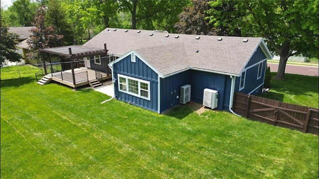 back of property featuring board and batten siding, a deck, roof with shingles, a gate, and ac unit