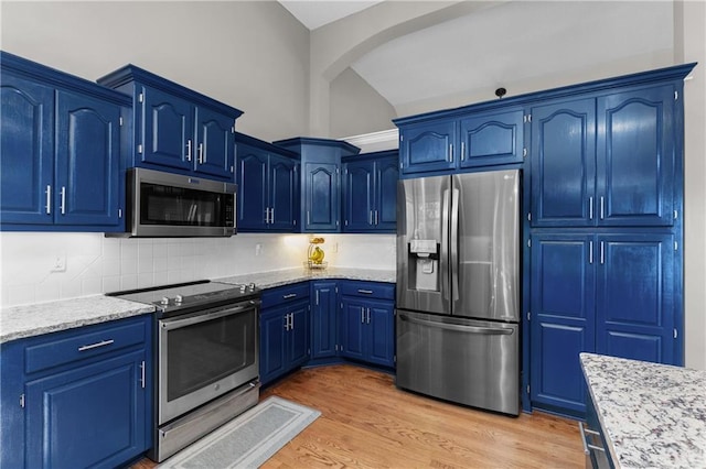 957 NW Dogwood Dr, Grain Valley, MO 64029 - kitchen with stainless steel appliances, lofted ceiling, decorative backsplash, light wood finished floors, and blue cabinetry