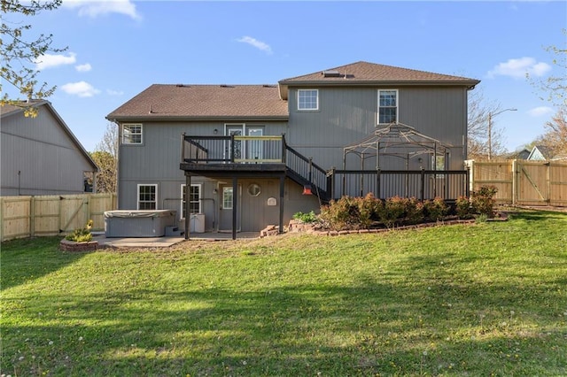 957 NW Dogwood Dr, Grain Valley, MO 64029 - back of property with a hot tub, a deck, a gate, a patio area, and roof with shingles