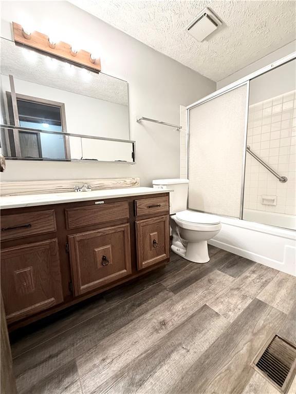 bathroom featuring vanity, a textured ceiling, visible vents, and wood finished floors