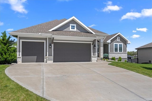 22622 W 87th Ter, Lenexa, KS 66227 - craftsman house featuring an attached garage, driveway, stone siding, a front yard, and roof with shingles