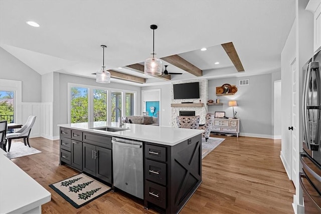 22622 W 87th Ter, Lenexa, KS 66227 - kitchen featuring a sink, stainless steel appliances, a large fireplace, light countertops, and a center island with sink