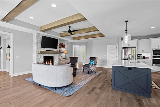 22622 W 87th Ter, Lenexa, KS 66227 - living room with baseboards, a fireplace, wood finished floors, a ceiling fan, and beam ceiling