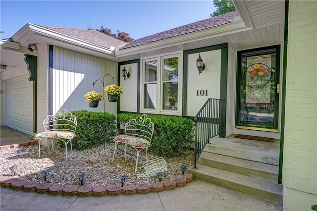 property entrance with a garage and a shingled roof