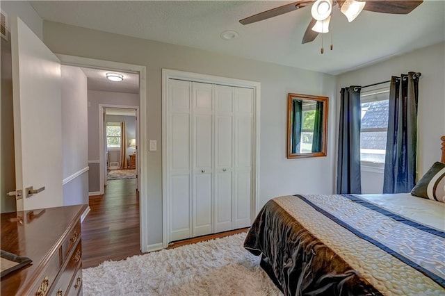 bedroom featuring a closet, dark wood-type flooring, visible vents, ceiling fan, and baseboards