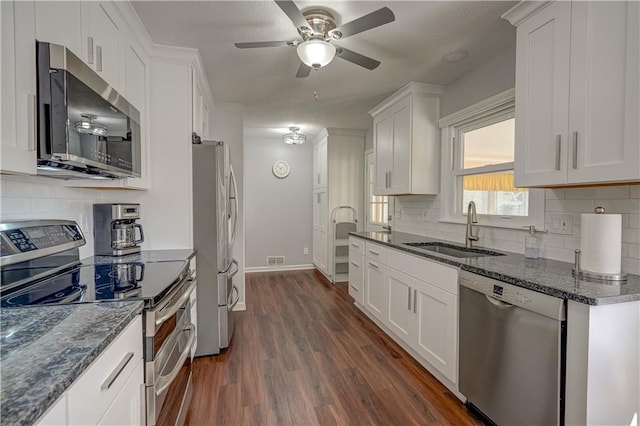 kitchen with visible vents, a sink, white cabinetry, dark wood-type flooring, and stainless steel appliances