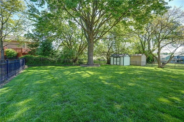 view of yard featuring a fenced backyard, a shed, and an outbuilding