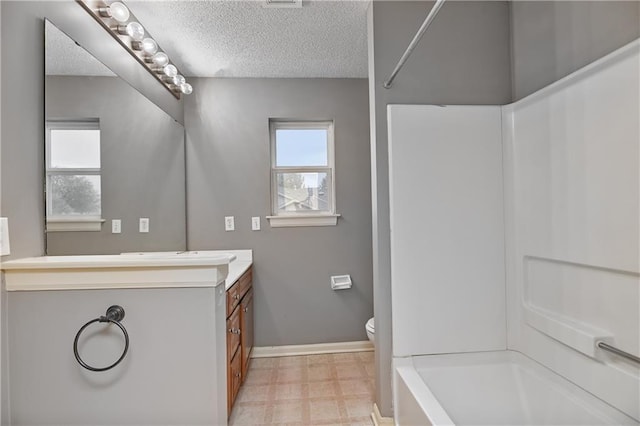 full bath featuring a textured ceiling, tile patterned floors, vanity, toilet, and baseboards