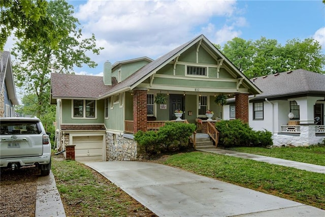 view of front facade with covered porch, concrete driveway, an attached garage, and stone siding