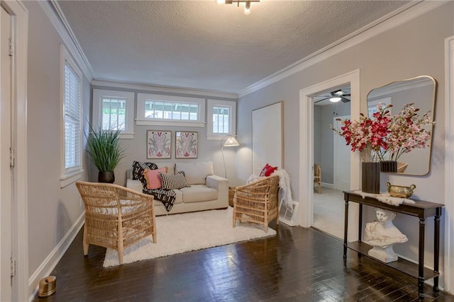 living area featuring crown molding, wood finished floors, a textured ceiling, baseboards, and a ceiling fan