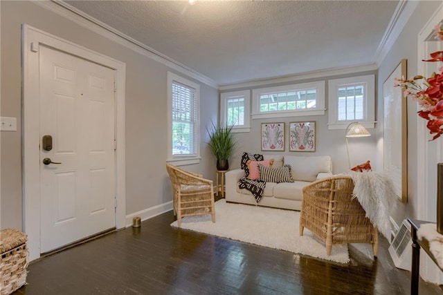 living area featuring crown molding, wood finished floors, baseboards, and a textured ceiling