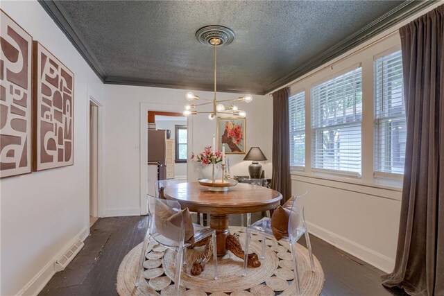 dining area with a textured ceiling, crown molding, a chandelier, baseboards, and dark wood-style floors