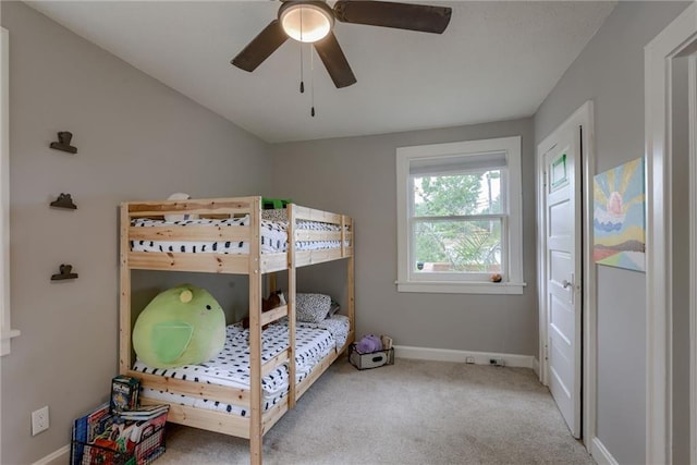 carpeted bedroom featuring baseboards and a ceiling fan
