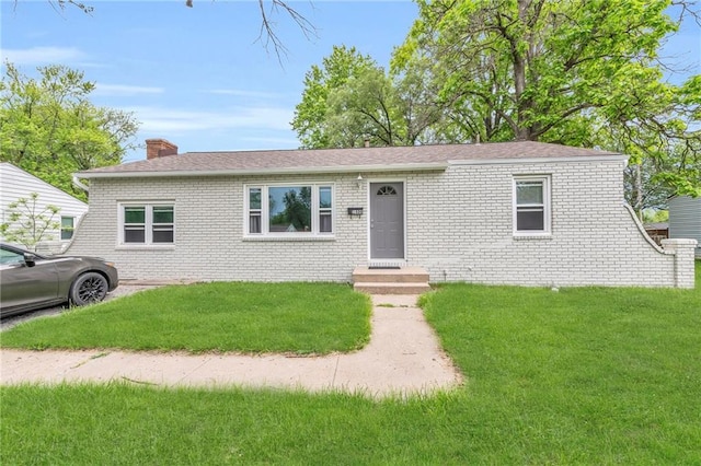1400 NE 67th Ter, Gladstone, MO 64118 - view of front facade featuring a front yard, brick siding, a chimney, and a shingled roof
