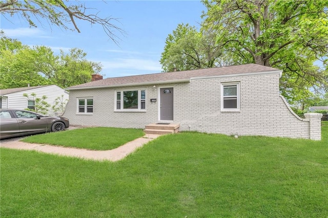 1400 NE 67th Ter, Gladstone, MO 64118 - view of front of home featuring a front lawn, brick siding, and a chimney