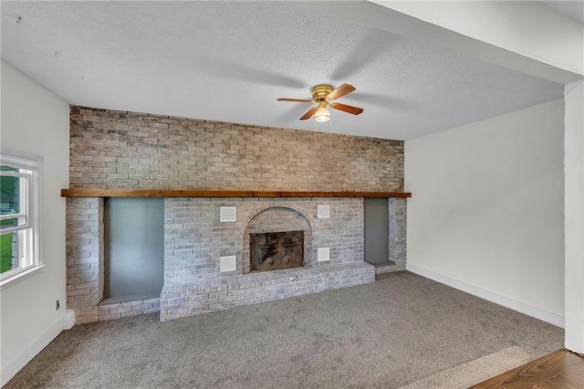 1400 NE 67th Ter, Gladstone, MO 64118 - unfurnished living room featuring ceiling fan, a fireplace, carpet flooring, a textured ceiling, and baseboards