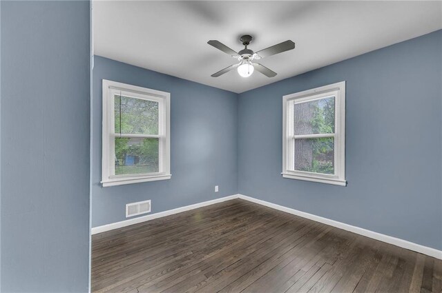 1400 NE 67th Ter, Gladstone, MO 64118 - spare room with healthy amount of natural light, dark wood finished floors, ceiling fan, and baseboards