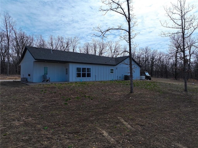exterior space featuring central air condition unit, board and batten siding, and a shingled roof