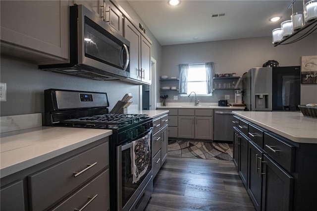 kitchen featuring stainless steel appliances, visible vents, open shelves, dark wood-type flooring, and light countertops