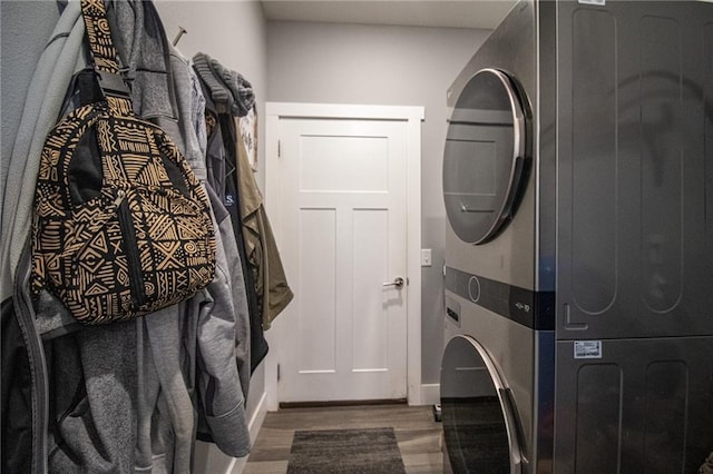 clothes washing area with stacked washing maching and dryer, laundry area, and wood finished floors