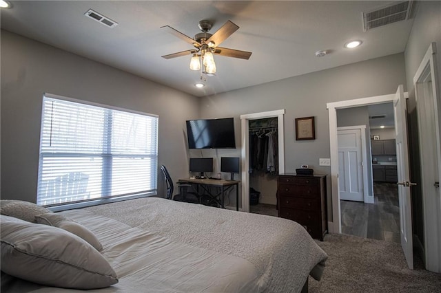 bedroom featuring carpet flooring, a closet, visible vents, and a walk in closet