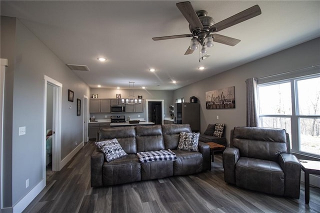 living room with recessed lighting, a wealth of natural light, and dark wood finished floors