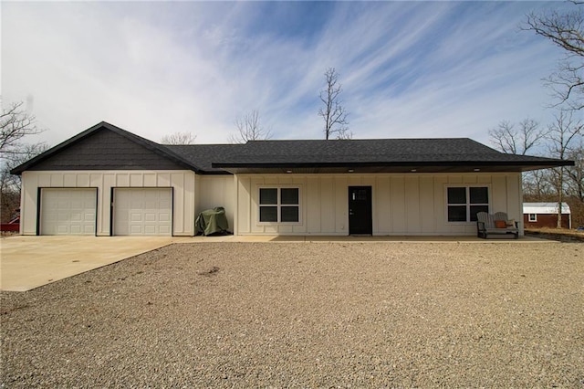 ranch-style home featuring roof with shingles, concrete driveway, an attached garage, and board and batten siding