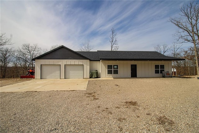 single story home with board and batten siding, an attached garage, a shingled roof, and driveway