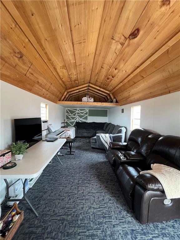 carpeted living room featuring wooden ceiling, lofted ceiling, and a fireplace