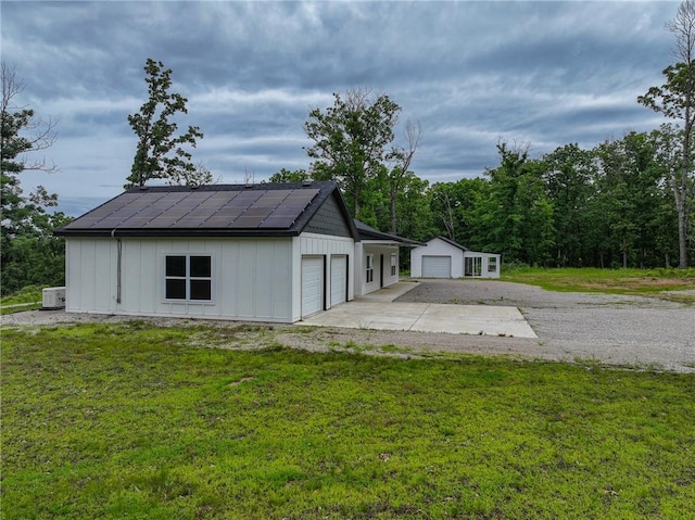 3813 Mt Horeb Rd, Camdenton, MO 65020 - view of front facade with board and batten siding, an outdoor structure, a front lawn, and solar panels